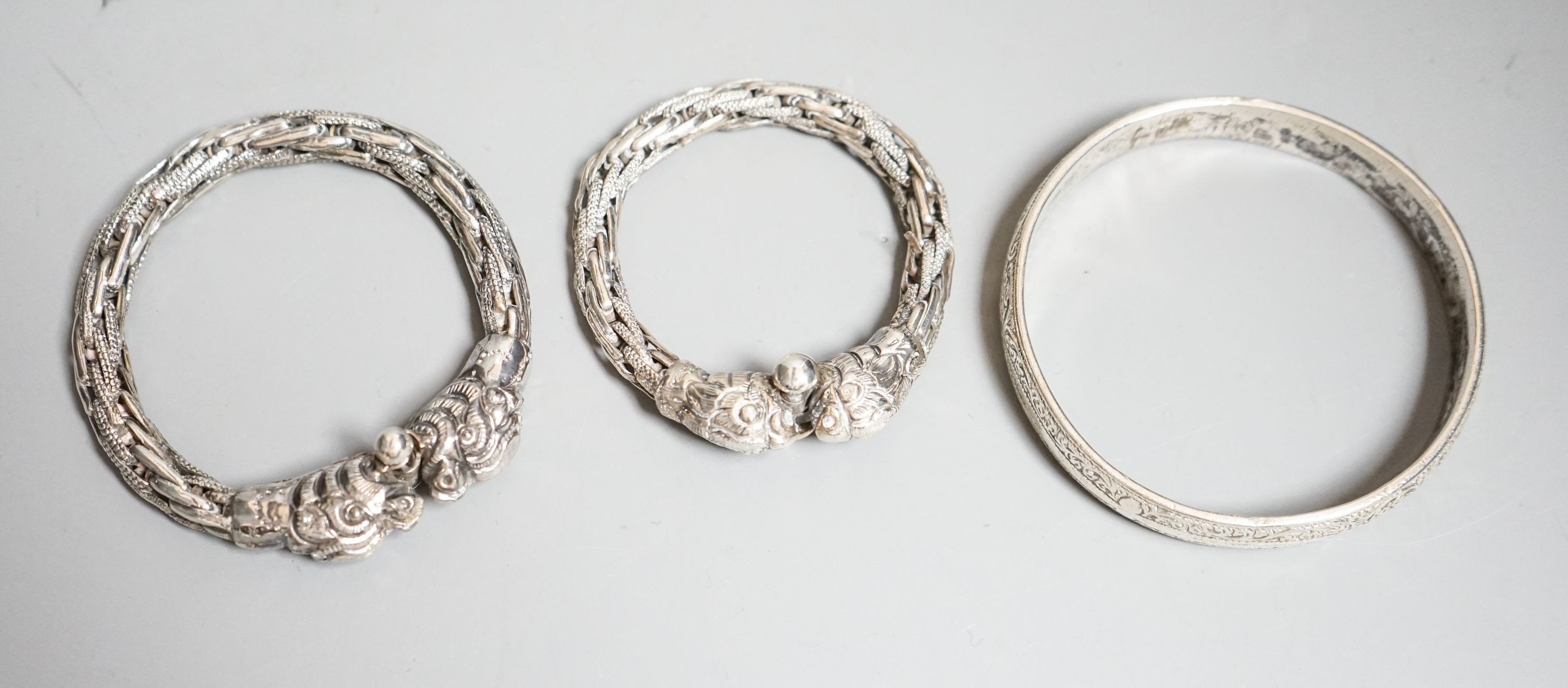 A cased Edwardian belt buckle, Goldsmiths & Silversmiths Co Ltd, London, 1908 and three bangles.